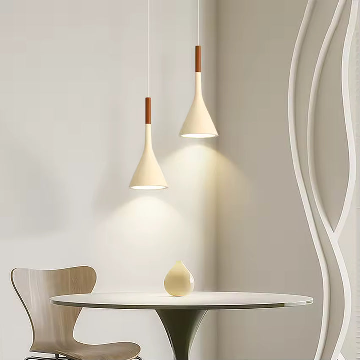 Luminaire conique en métal blanc dans une salle à manger épurée, avec éclairage chaud et silhouette nordique