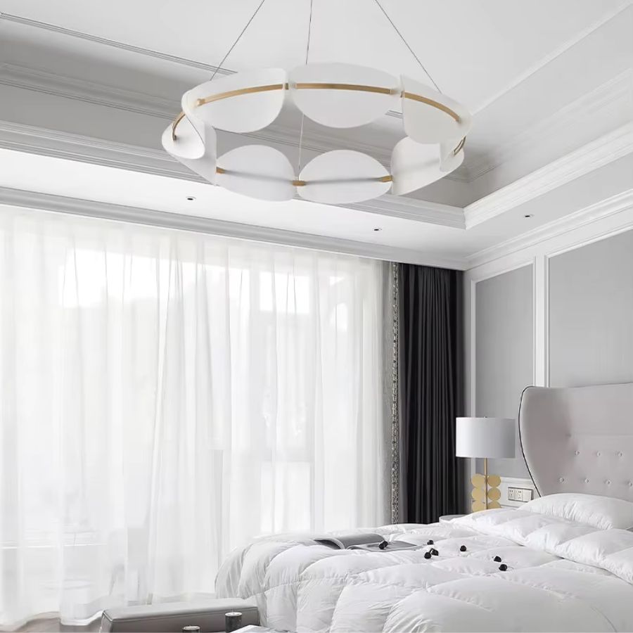Luminaire en couronne à pétales blancs et cercle doré, suspendu dans une chambre au style élégant et contemporain