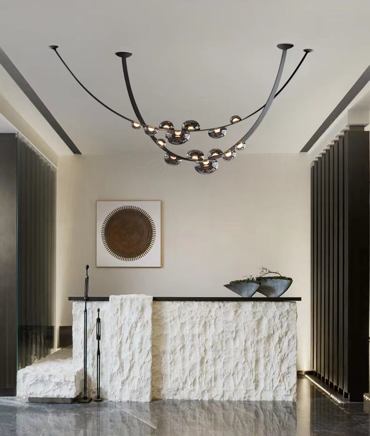 Magnifique luminaire suspendu en cuir et sphères de verre illuminant un hall d'entrée contemporain.