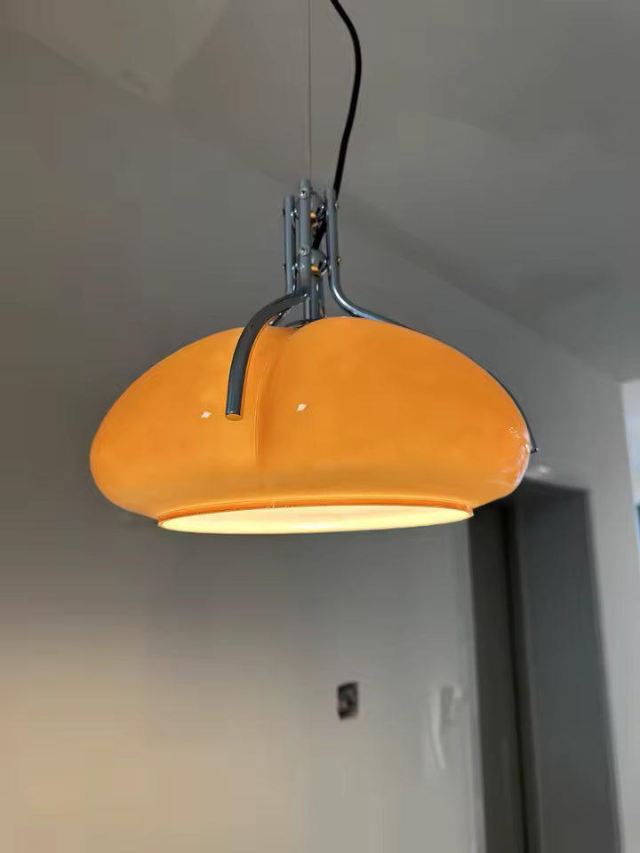 Gros plan sur le dôme orange brillant et son armature chromée, au style Space Age rétro-futuriste