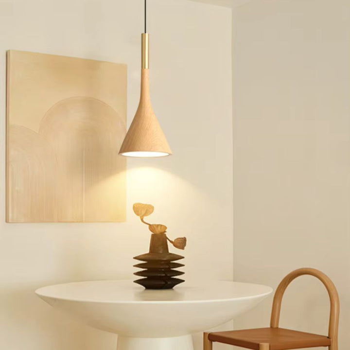 Au-dessus d’une table épurée, ce luminaire conique effet bois clair apporte une lumière douce d’inspiration japandi