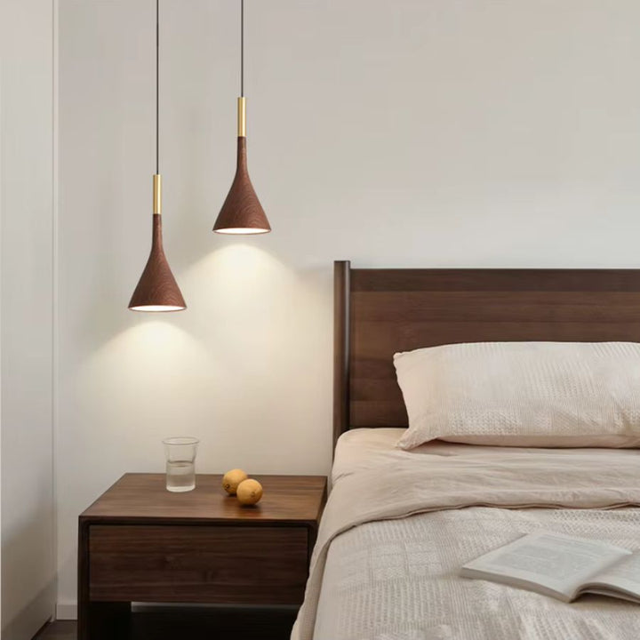Au-dessus du chevet, deux luminaires coniques effet noyer et laiton soulignent une chambre sobre au style minimaliste