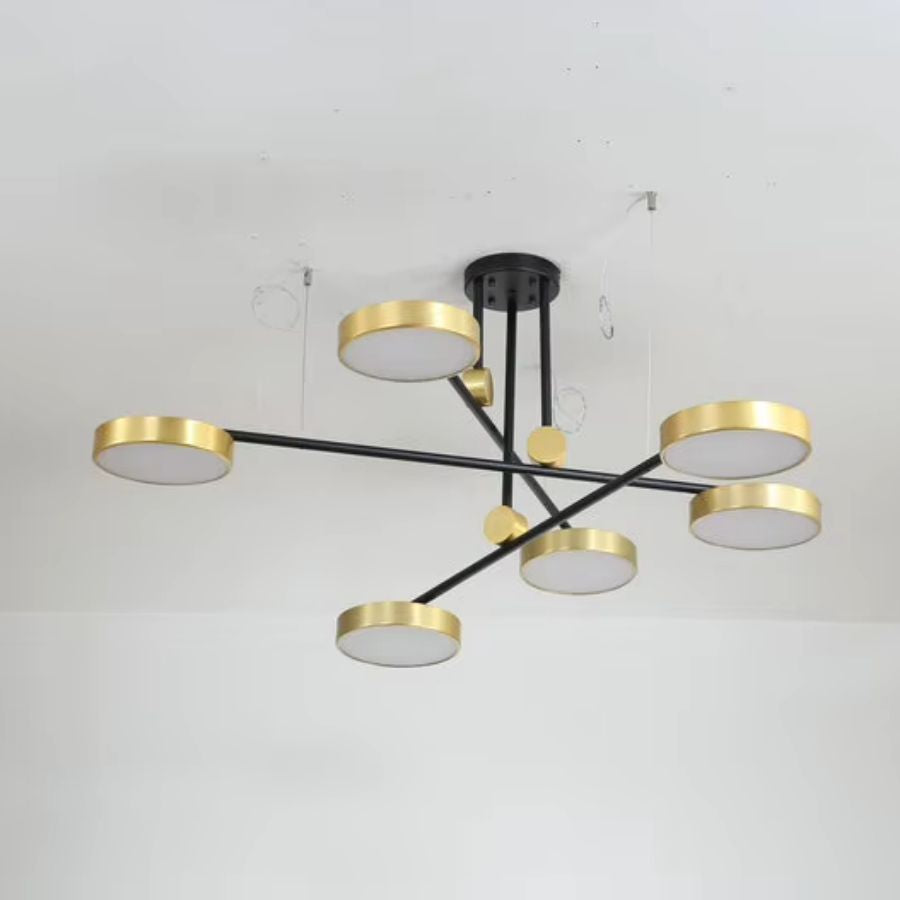 À l’arrêt, le luminaire dévoile une composition géométrique de bras noirs et de disques dorés au style moderne.
