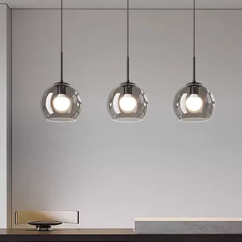 Alignés avec sobriété, trois globes en verre fumé soulignent le style minimaliste de ce luminaire noir
