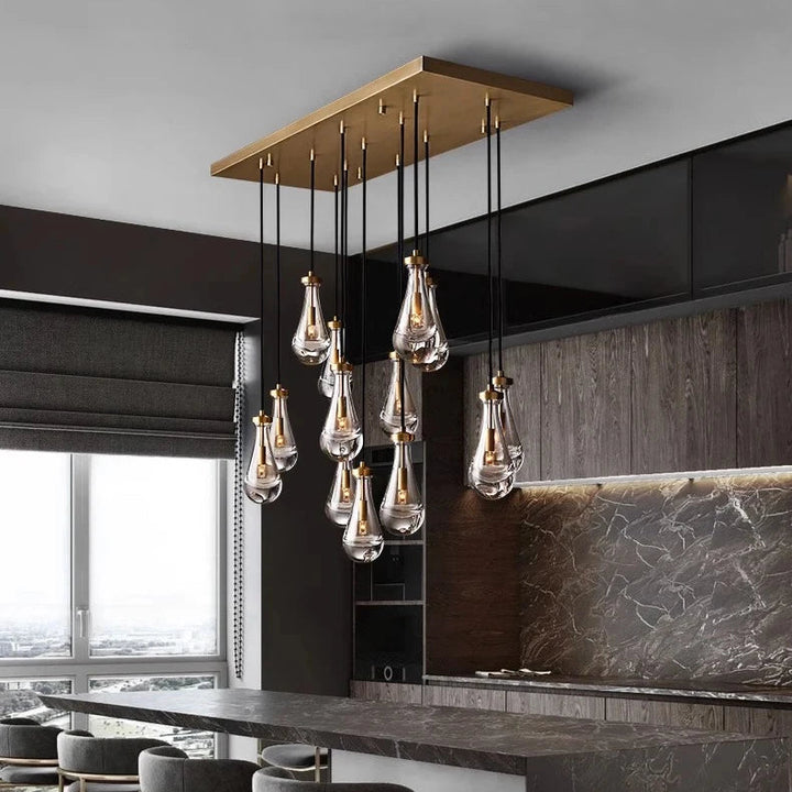 Luminaire design en gouttes d'eau de verre suspendues, idéal pour illuminer un îlot de cuisine contemporain.