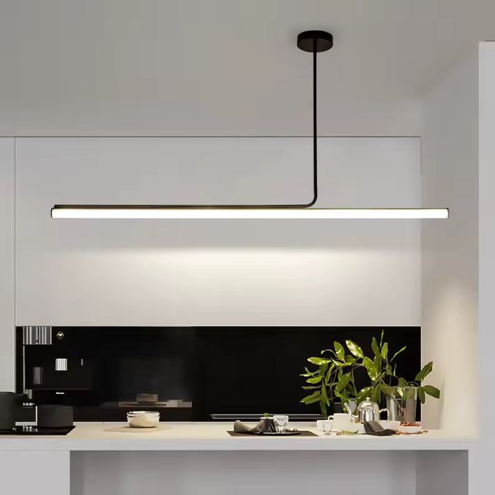 Éclairage graphique avec ce luminaire linéaire LED noir, suspendu au-dessus d’un plan de travail dans une cuisine minimaliste.