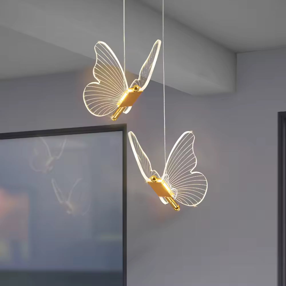 Dans un intérieur contemporain, deux papillons lumineux forment un luminaire aérien aux ailes transparentes