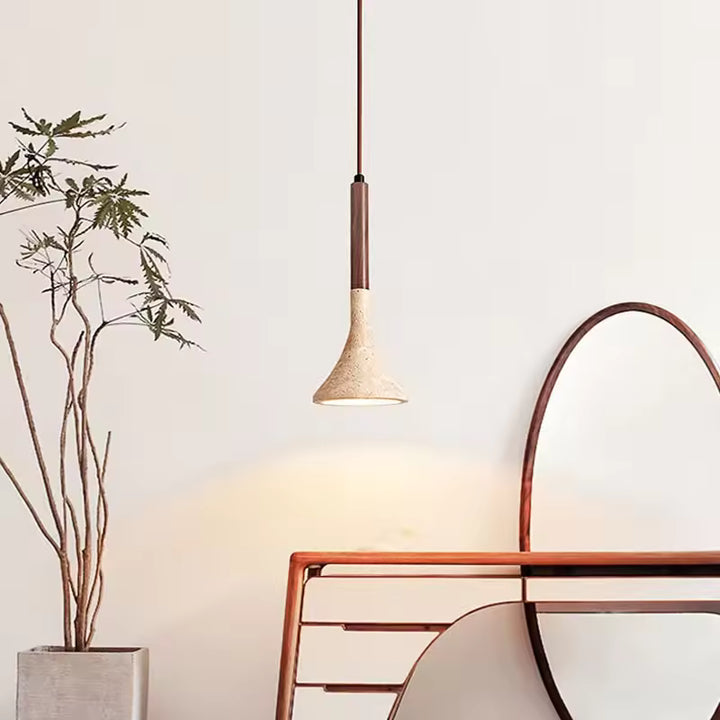 Bois foncé et pierre claire composent un luminaire élancé au style organique, dans un intérieur sobre et naturel