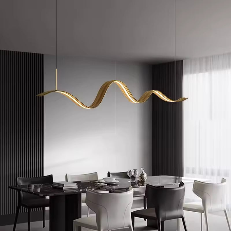 Au-dessus d’une table élégante, ce luminaire ruban LED doré affirme un design organique aux lignes souples et raffinées