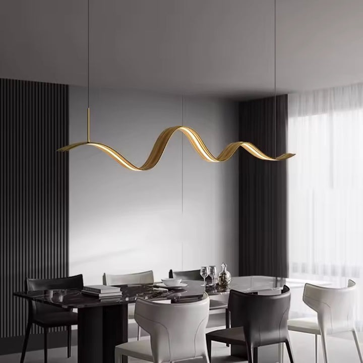Au-dessus d’une table élégante, ce luminaire ruban LED doré affirme un design organique aux lignes souples et raffinées