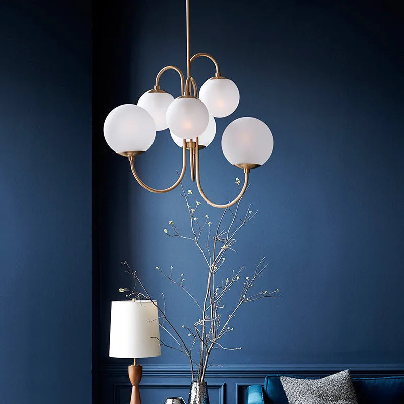 Luminaire scandinave élégant en laiton et verre opalin dans un salon feutré aux murs bleu marine et aux bouquets dorés.