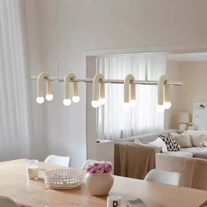 Gros plan sur le luminaire suspendu à arches blanches et globes lumineux au-dessus d'une table à manger