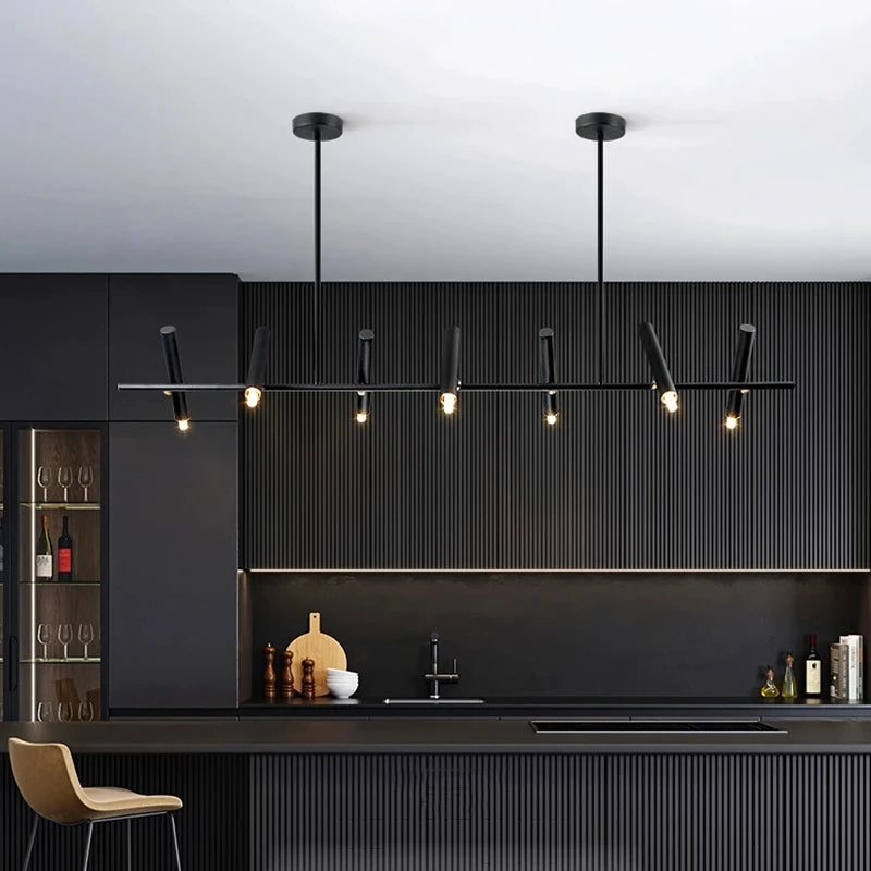 Luminaire suspendu noir à cylindres orientables dans une cuisine contemporaine épurée.