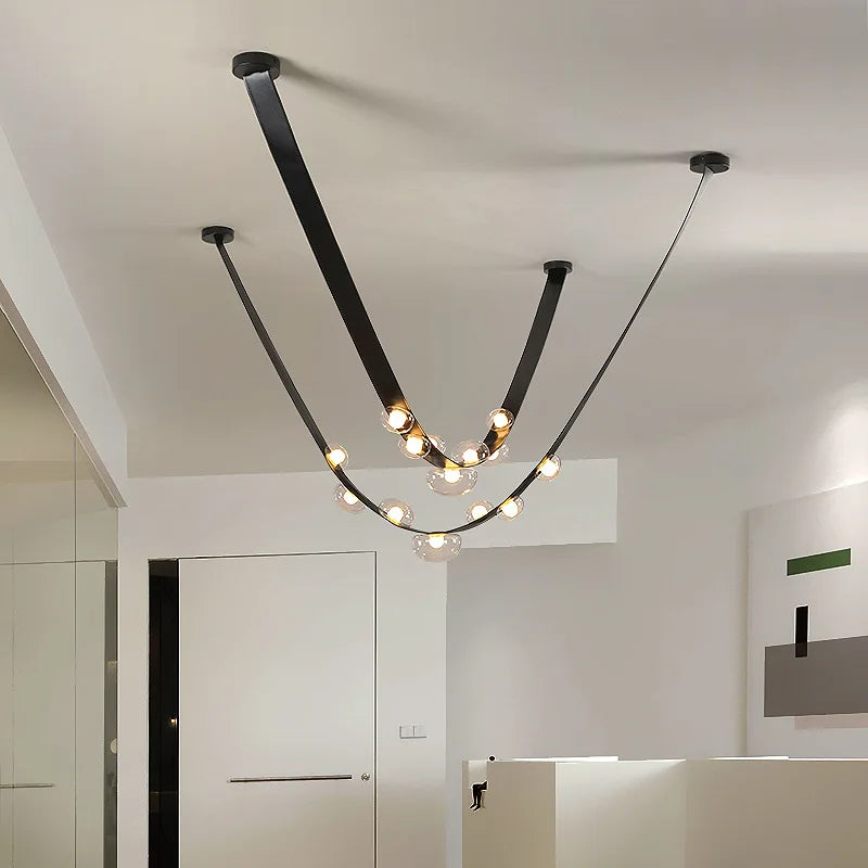 Luminaire d'exception aux lignes graphiques en cuir noir soulignées par des globes lumineux aériens.