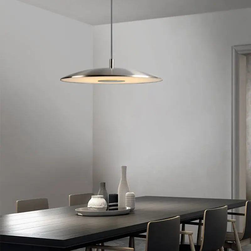 Suspension lumineuse contemporaine installée au-dessus d'une grande table de salle à manger moderne.