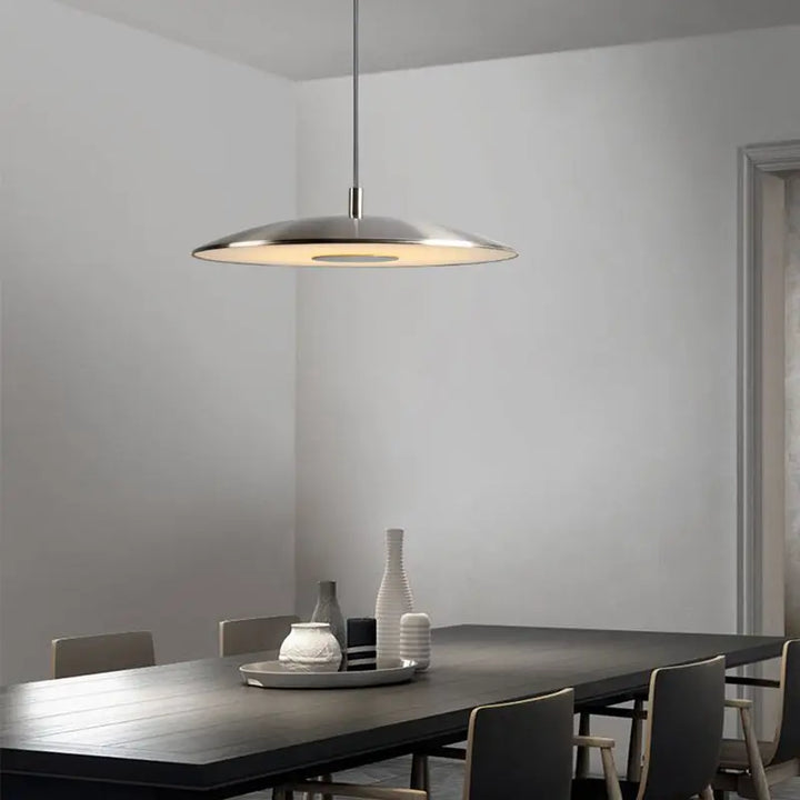 Suspension lumineuse contemporaine installée au-dessus d'une grande table de salle à manger moderne.