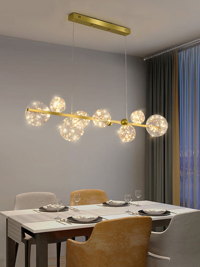 Luminaire suspendu doré au-dessus d'une table à manger dans une pièce au design contemporain