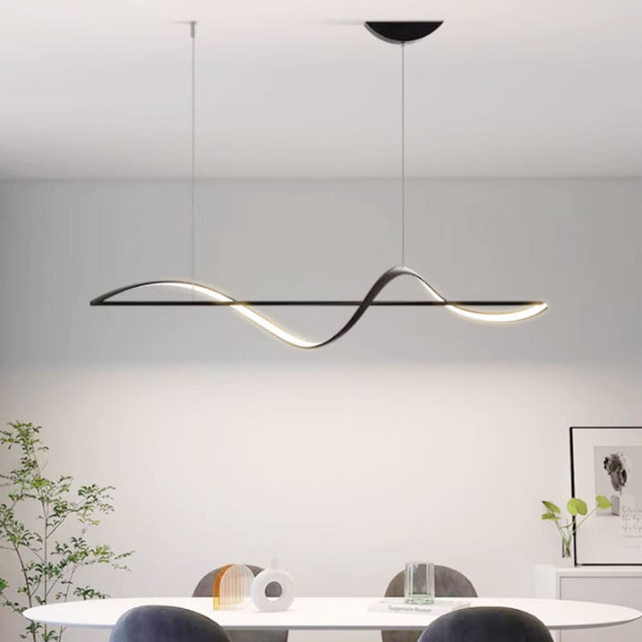 Luminaire suspendu noir minimaliste créant une ambiance épurée au-dessus du mobilier de salle à manger.