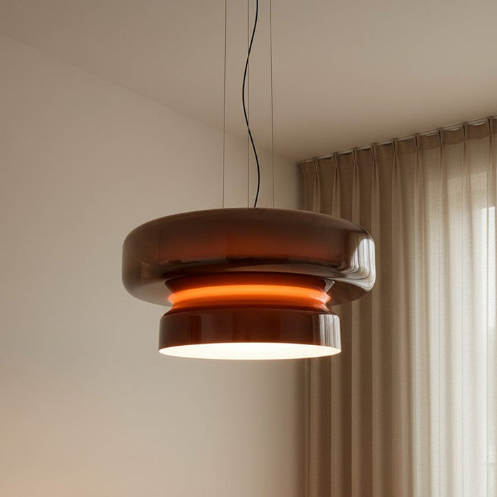 Luminaire suspendu au style rétro pop en verre rouge diffusant un éclairage chaleureux et feutré.