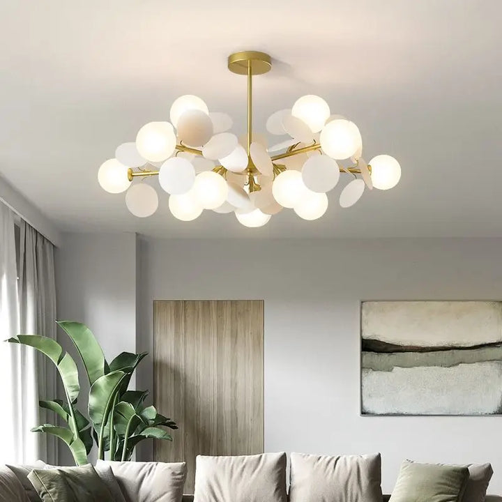 Luminaire suspendu chic doré avec pétales et globes en verre blanc dans un salon moderne