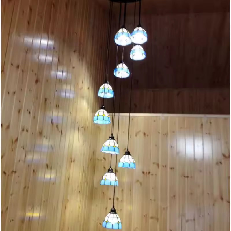 Luminaire Tiffany bleu à dix abat-jour étagés, sublimant de ses reflets colorés un intérieur de style chalet