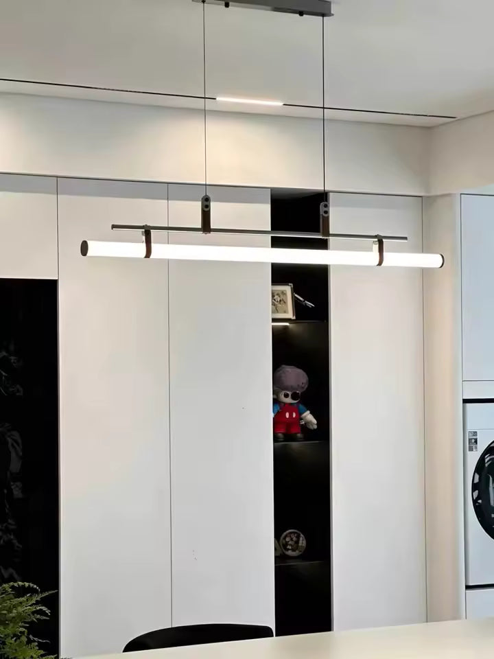 Luminaire tube LED noir à attaches en cuir, suspendu dans un intérieur contemporain aux lignes épurées