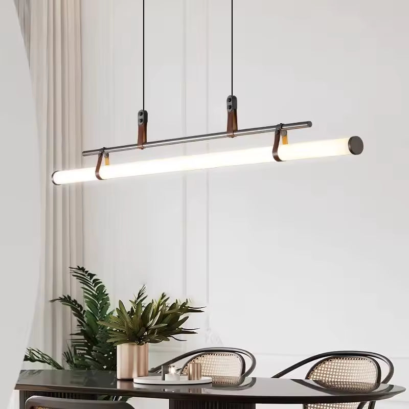 Éclairage linéaire à tube LED, structure noire et attaches en cuir, au-dessus d’une table contemporaine