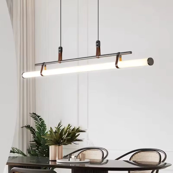 Éclairage linéaire à tube LED, structure noire et attaches en cuir, au-dessus d’une table contemporaine