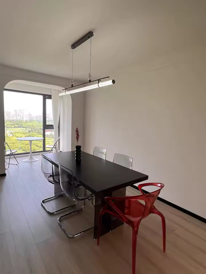 Luminaire linéaire LED noir avec attaches en cuir, suspendu au-dessus d’une grande table au style minimaliste