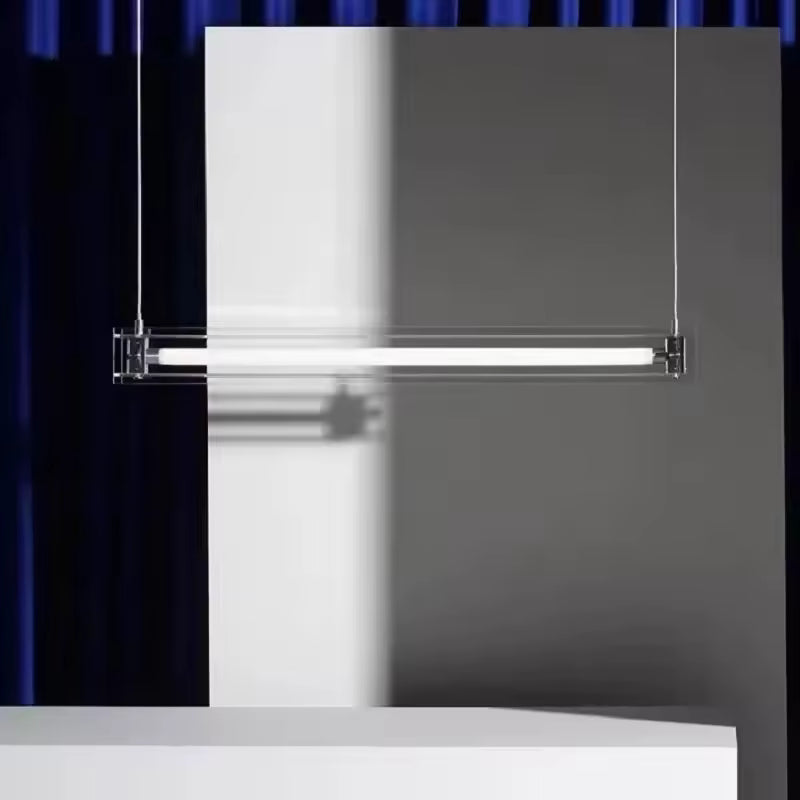 Luminaire tube en verre transparent et acier inoxydable, au design minimaliste souligné par une lumière linéaire