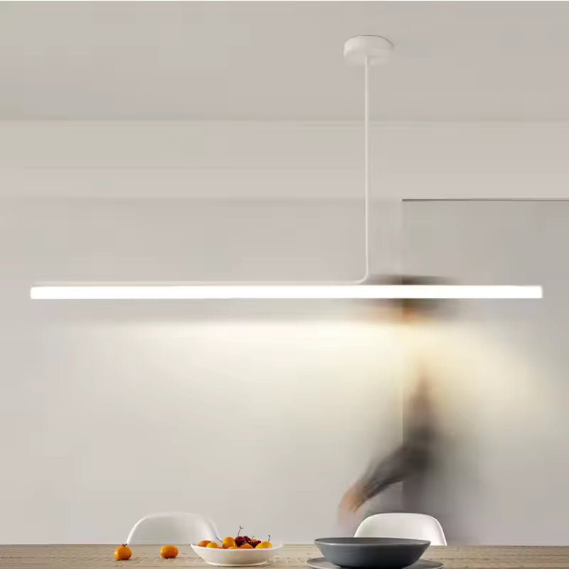 Luminaire tubulaire LED blanc au design épuré, suspendu au-dessus d’une table dans une salle à manger contemporaine.