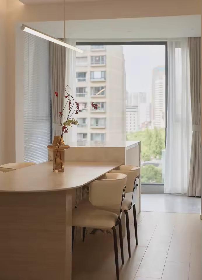 Épurée et discrète, cette suspension tubulaire LED blanche accompagne une salle à manger lumineuse au style contemporain.