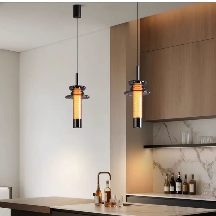 Deux luminaires tubulaires en verre fumé éclairent un îlot de cuisine dans un esprit industriel contemporain