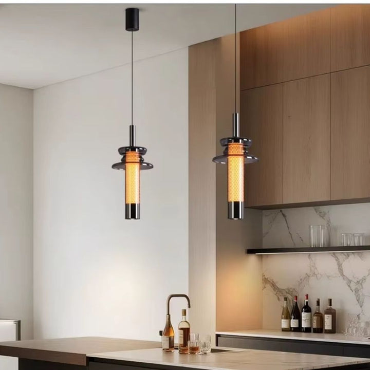 Deux luminaires tubulaires en verre fumé éclairent un îlot de cuisine dans un esprit industriel contemporain