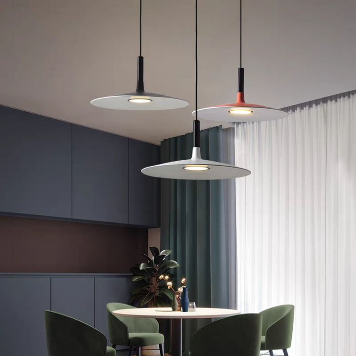Coin repas cosy éclairé par un luminaire UFO au design extra-plat dans un appartement.