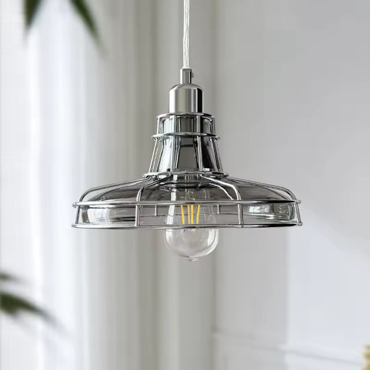 Vue de face d’une suspension chromé avec large diffuseur en verre transparent au style industriel rétro et Bauhaus