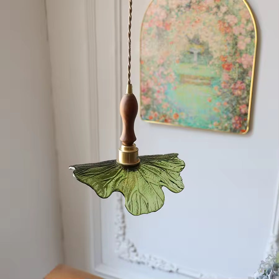 Vue arrière d’un luminaire en verre vert nervuré, bois de noyer et laiton, à l’allure végétale et poétique