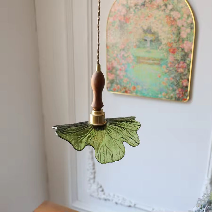 Vue arrière d’un luminaire en verre vert nervuré, bois de noyer et laiton, à l’allure végétale et poétique