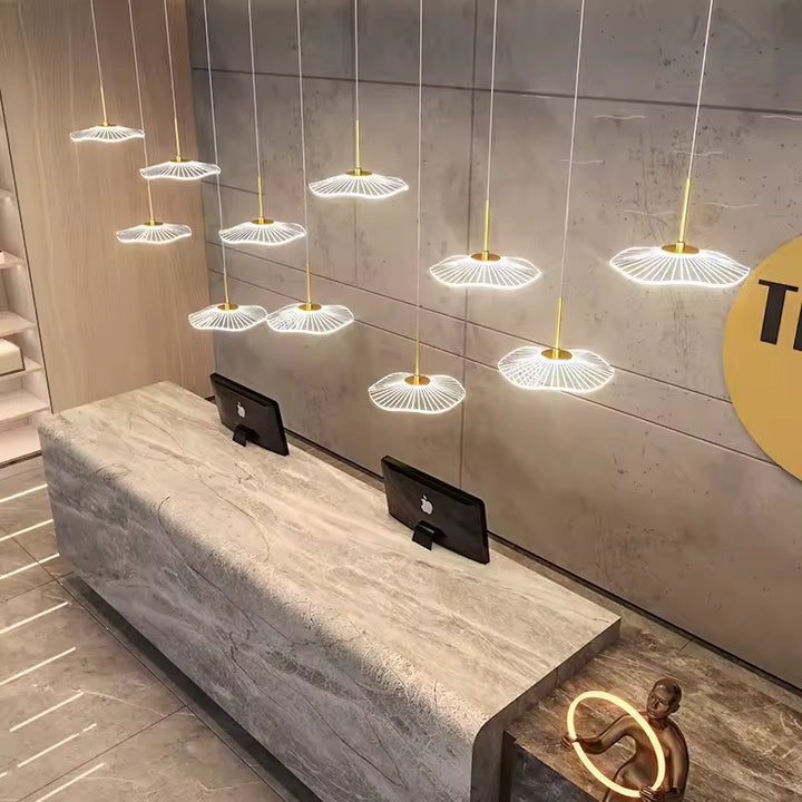 Au-dessus d'une réception en marbre, onze ombrelles LED suspendues à différentes hauteurs créent un décor lumineux sculptural.