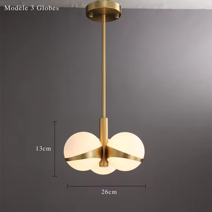 Trois globes lumineux réunis autour d’une structure dorée, pour un lustre compact au style minimaliste