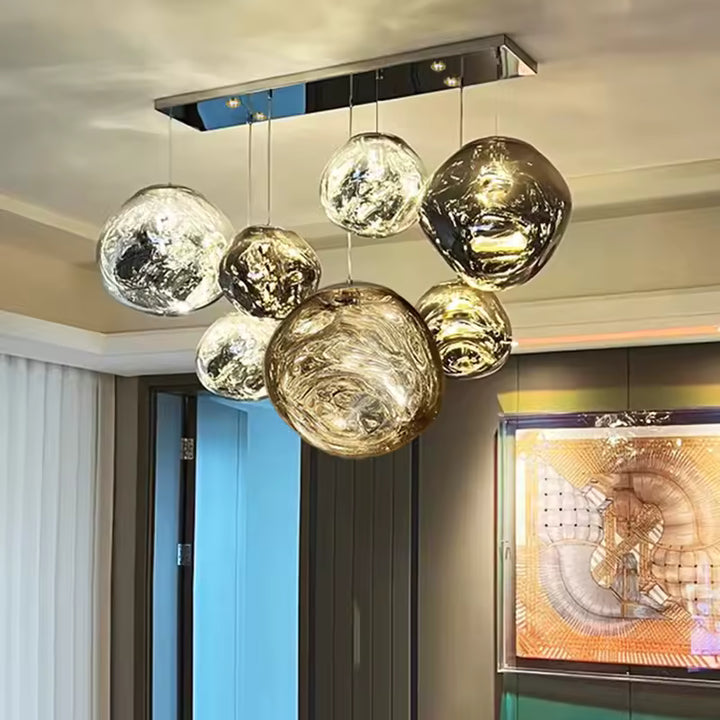 Une composition sculpturale de sept globes en verre ondulé, mêlant transparence et reflets ambrés dans un salon élégant.