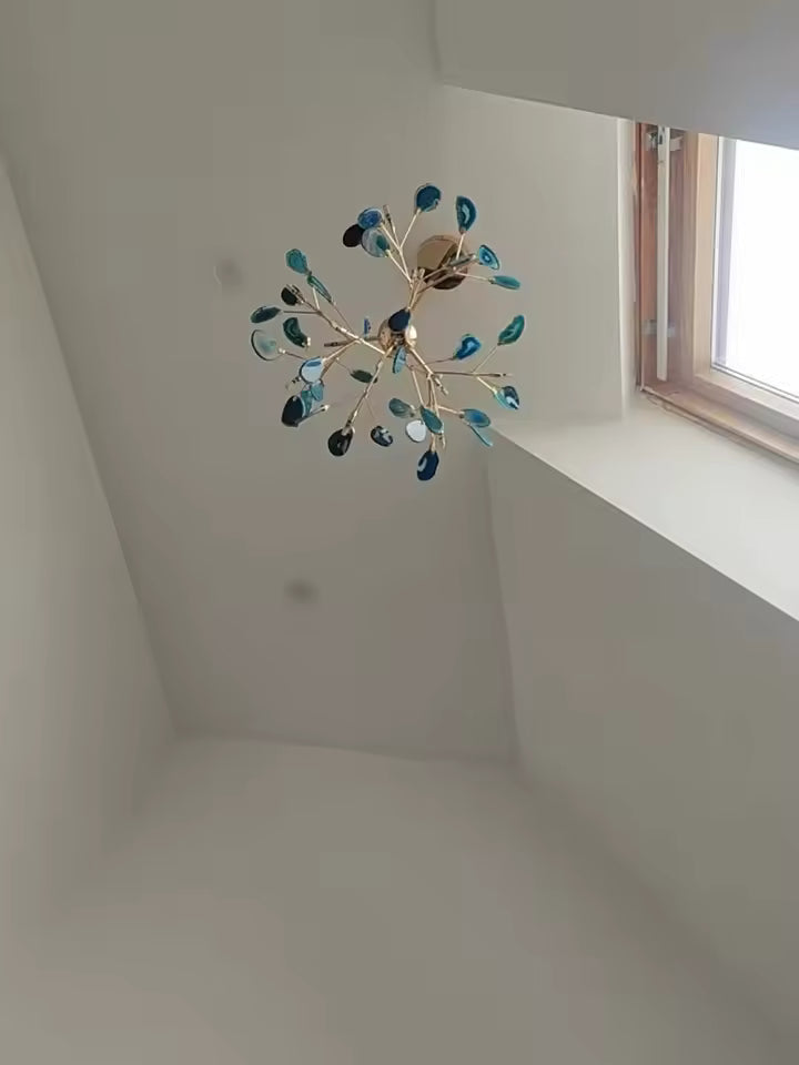 Lustre bleu en agate naturelle vu du dessous, aux ramifications dorées inspirées d’un design organique
