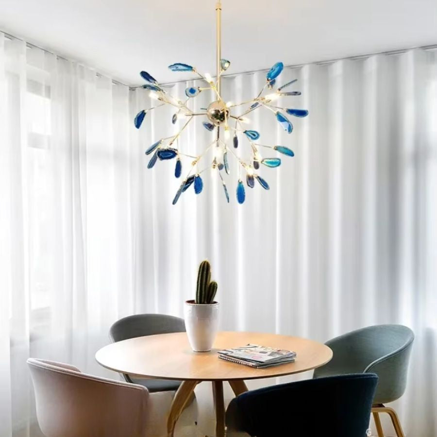 Lustre en agate bleue aux branches dorées, design végétal et élégant au-dessus d’une table de salle à manger