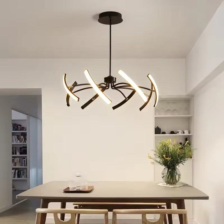 Au-dessus de la table, ce lustre araignée design aux bras LED courbés forme une suspension araignée contemporaine.