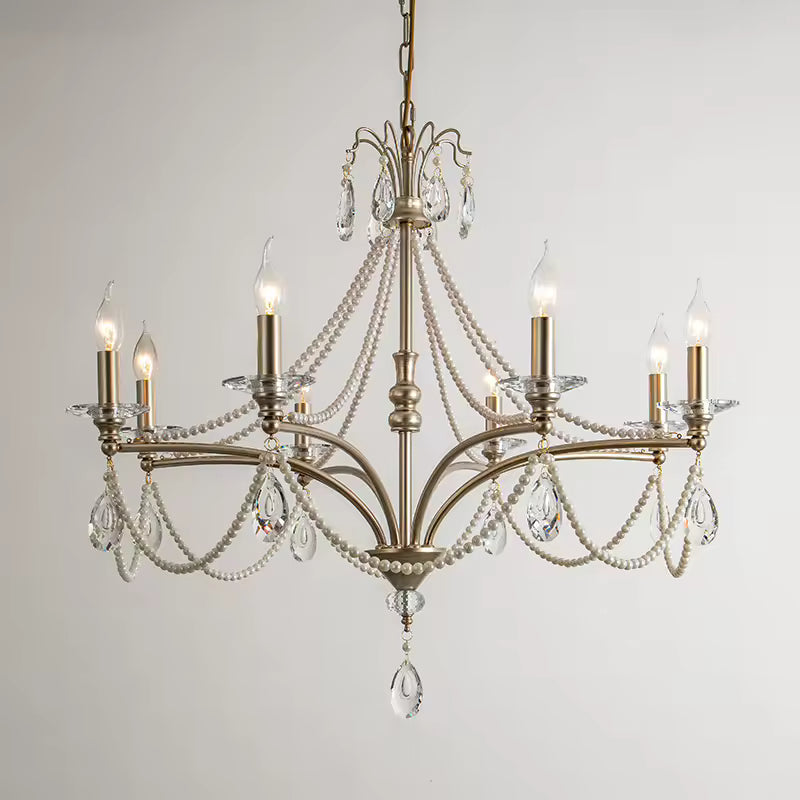 Lustre argenté de style classique à six bras courbés, pampilles de cristal et guirlandes de perles décoratives.