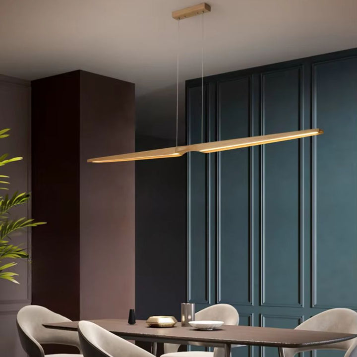 Lustre LED en bois clair au design japandi, avec ligne sculpturale fine dans une salle à manger élégante