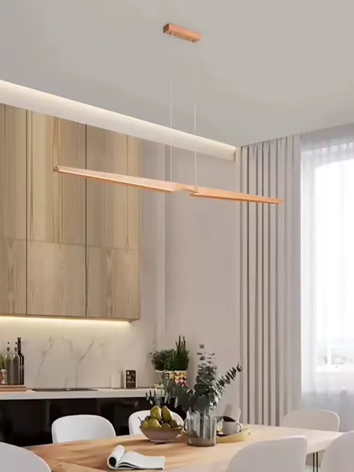Lustre LED en bois clair naturel au style japandi, suspendu au-dessus d’une table dans une salle à manger lumineuse