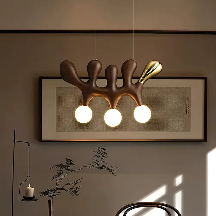 Suspension en bois foncé aux formes organiques, ponctuée de trois globes blancs dans un décor contemporain
