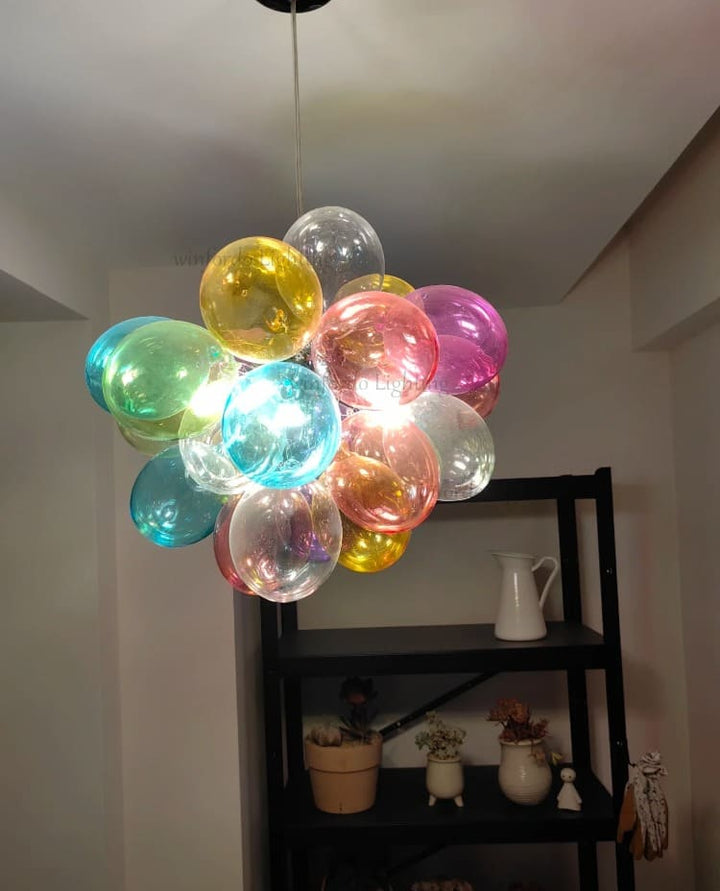 Lustre élégant en verre translucide multicolore diffusant une lumière éclatante au plafond.