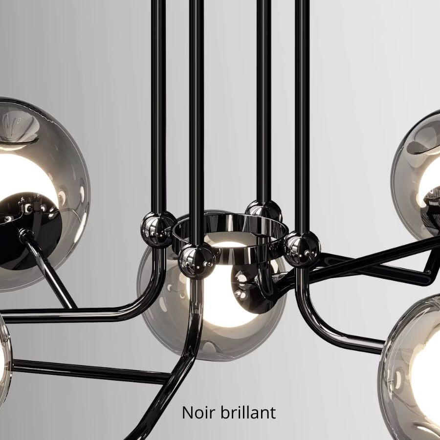 Gros plan sur un lustre branche noir brillant à globes en verre, révélant une structure sculpturale au style design